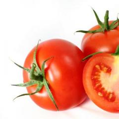 Tomat direndam menjadi dua bagian dengan bawang putih untuk musim dingin